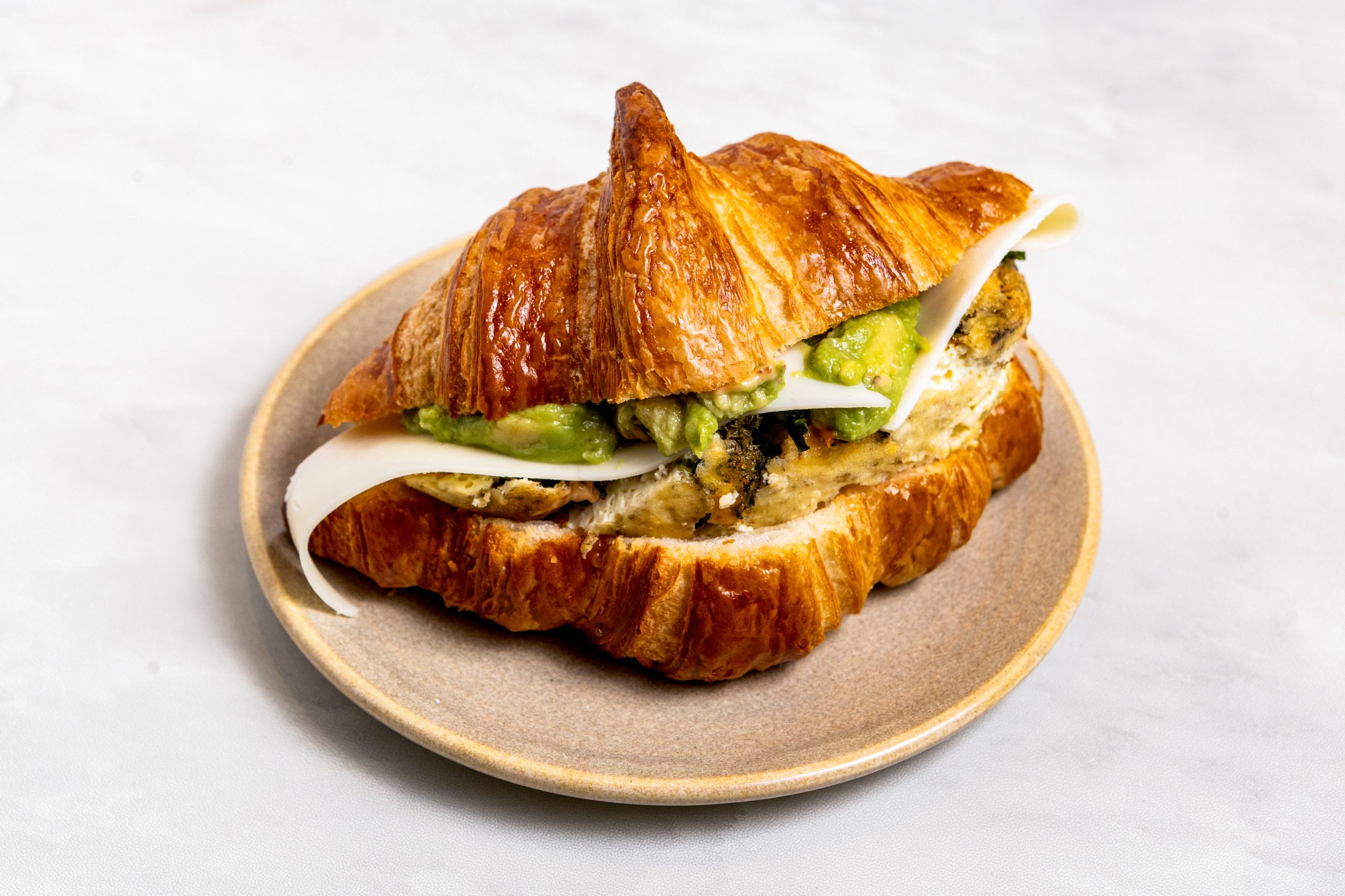 Our 2 Egg Bake with Mozza Avocado & Sun-Dried Tomato on a Flaky Croissant